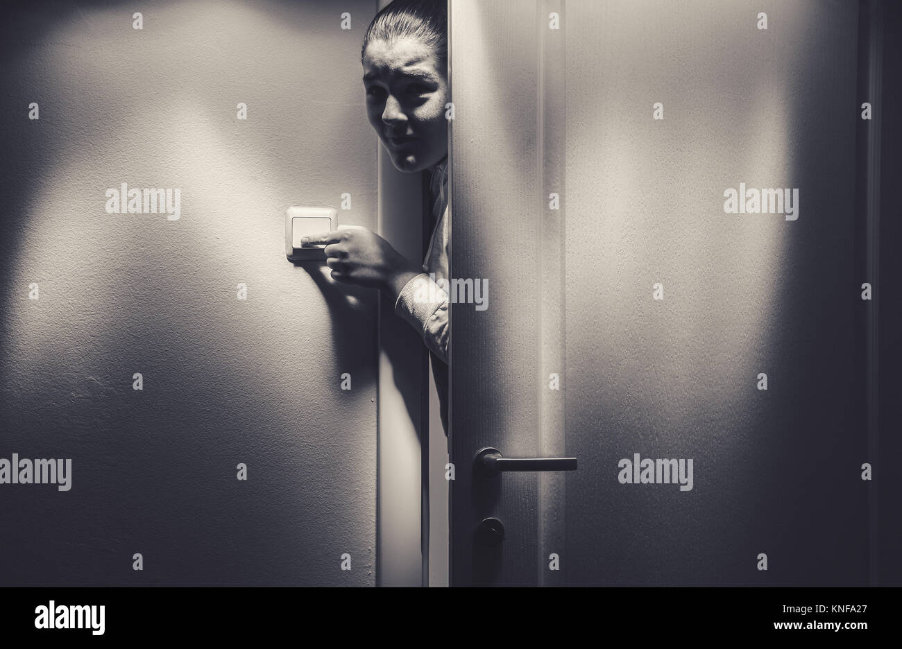 Portrait of a young girl entering the dark room. Stock Photo