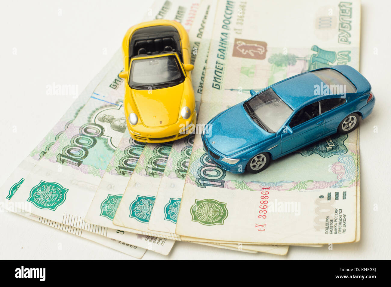 toy cars on Bank of Russia's paper banknotes, a white background ...