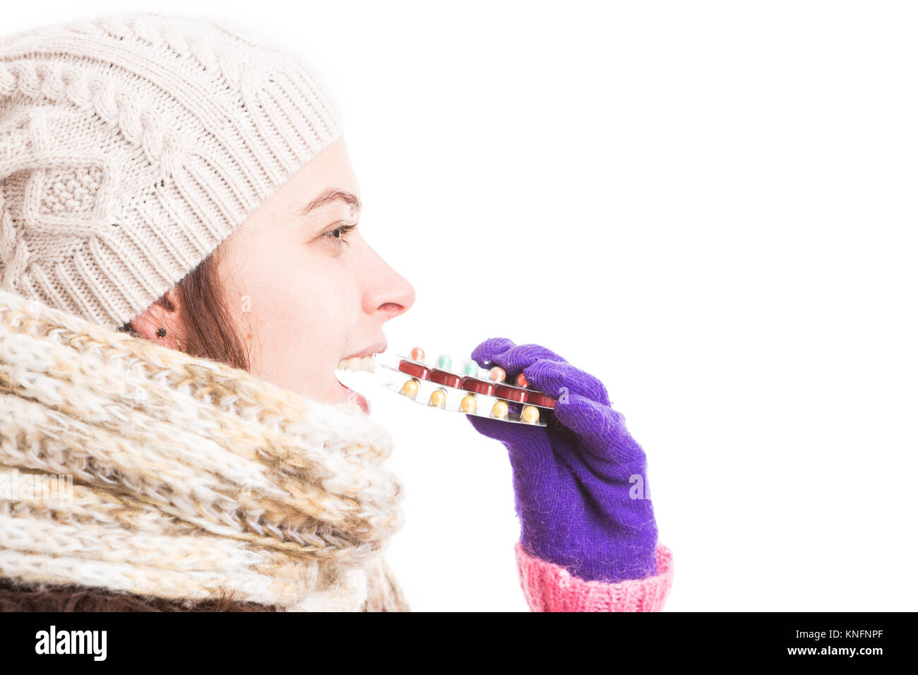 Woman with flu taking bunch of pills wearing warm clothes hat and gloves as grippe or influenza concept Stock Photo