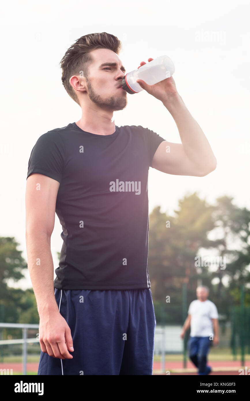 Man drinking from water bottle during sports Stock Photo