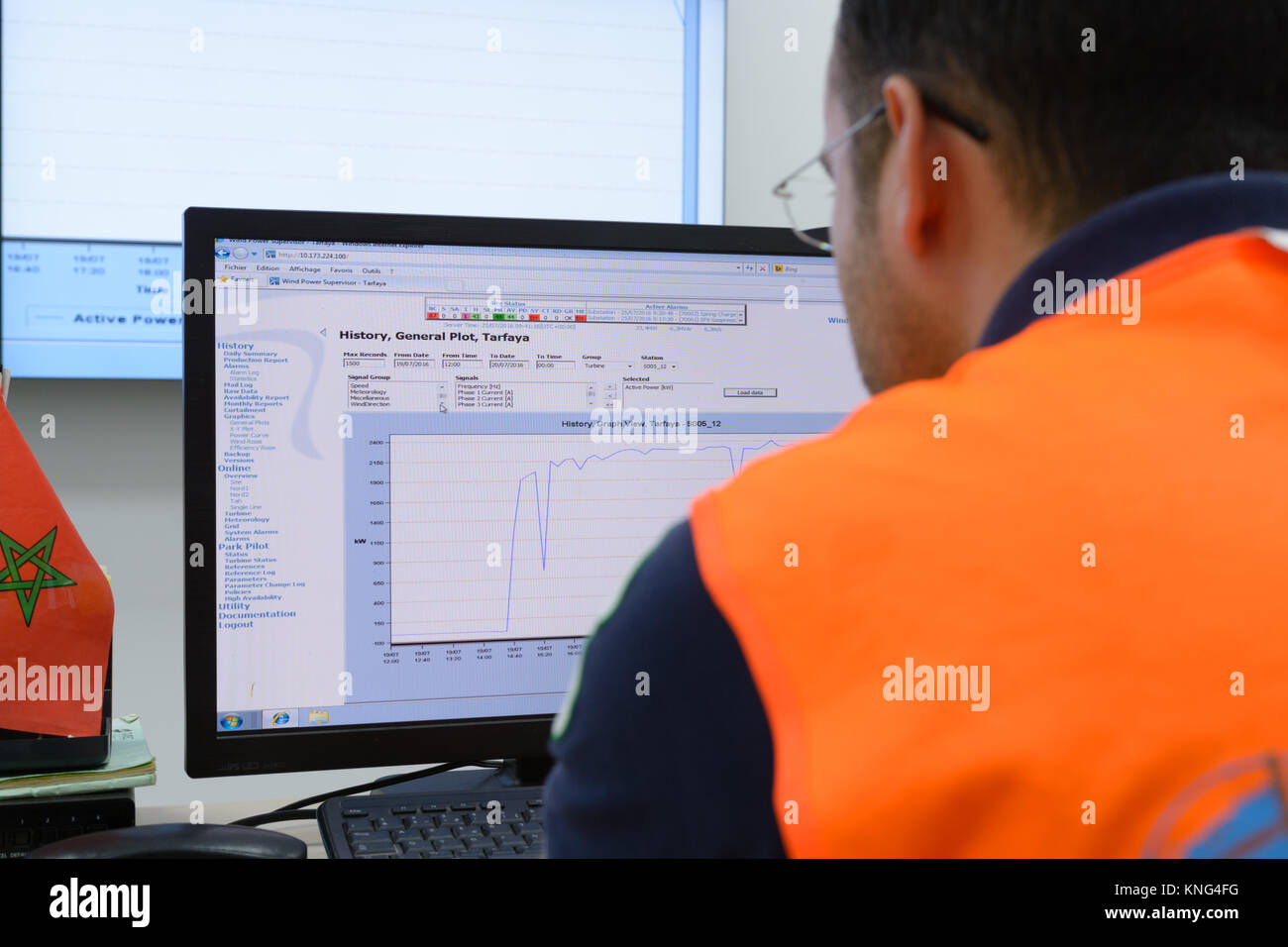 engineer carefully analyzing the monitoring data in Noor's control room