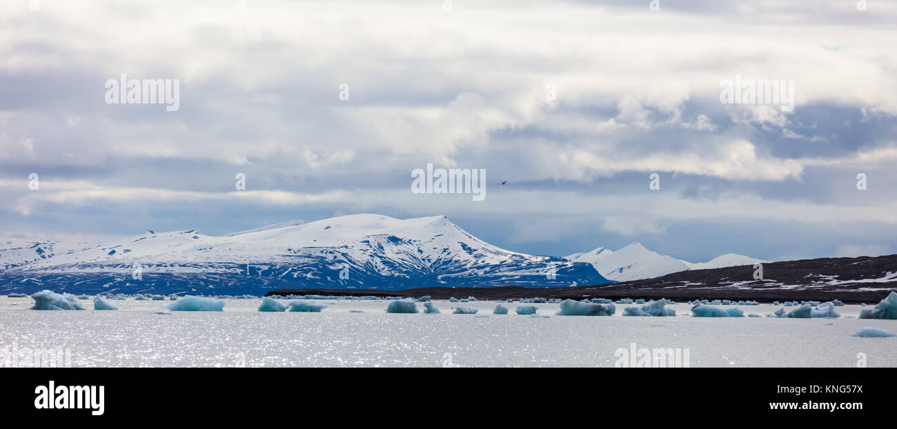 Panorama of floating sea ice in front of snowy mountains in the arctic Stock Photo