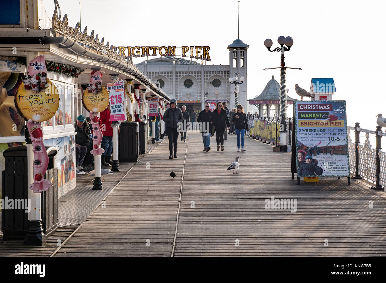 People strolling along Brighton Pier, Sussex, England, UK. Stock Photo