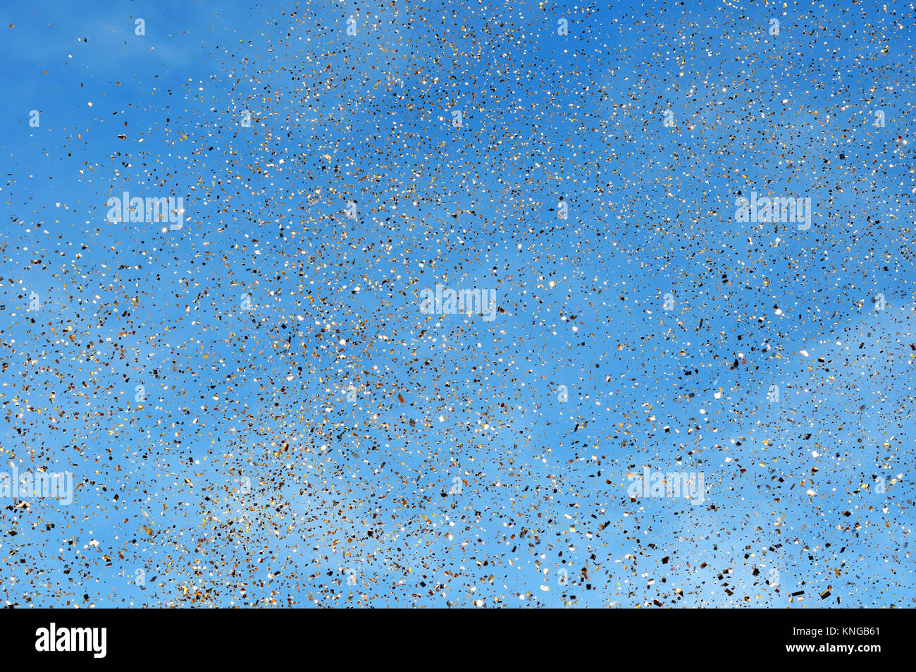 falling golden confetti in the city festival on blue sky background ...