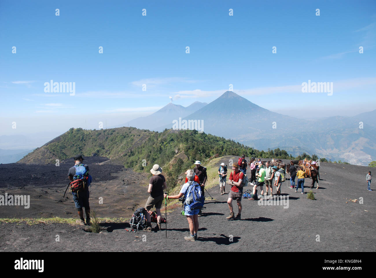 trekkers on the active volcano of Pacaya in Guatemala with Agua and Fuego volcanoes in the background Stock Photo
