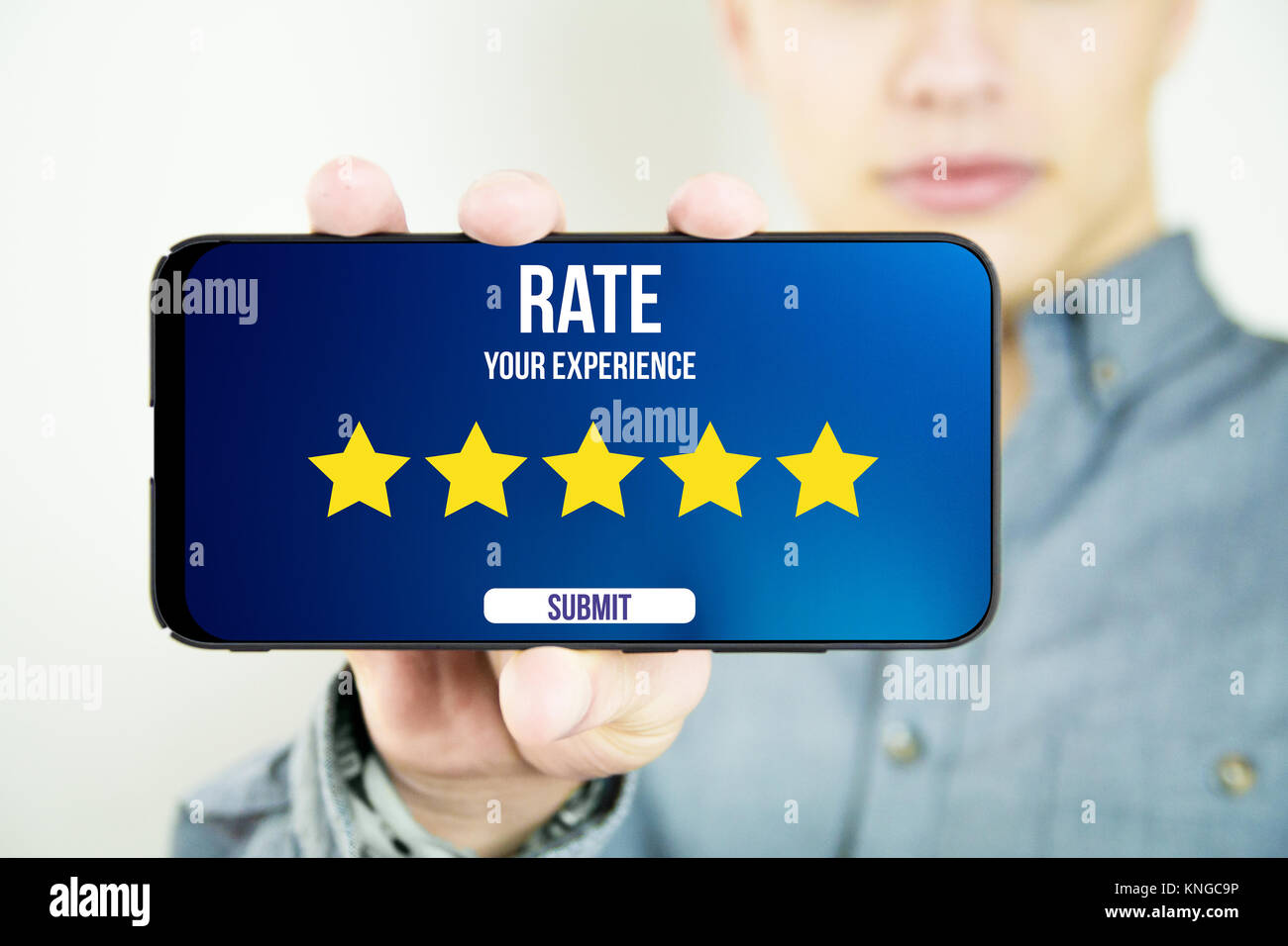 young man holding and showing a 5 stars ratingy full screen smartphone Stock Photo