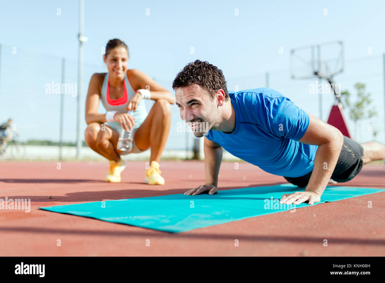 Young, beautiful, fit and healthy personal trainer counting push Stock Photo