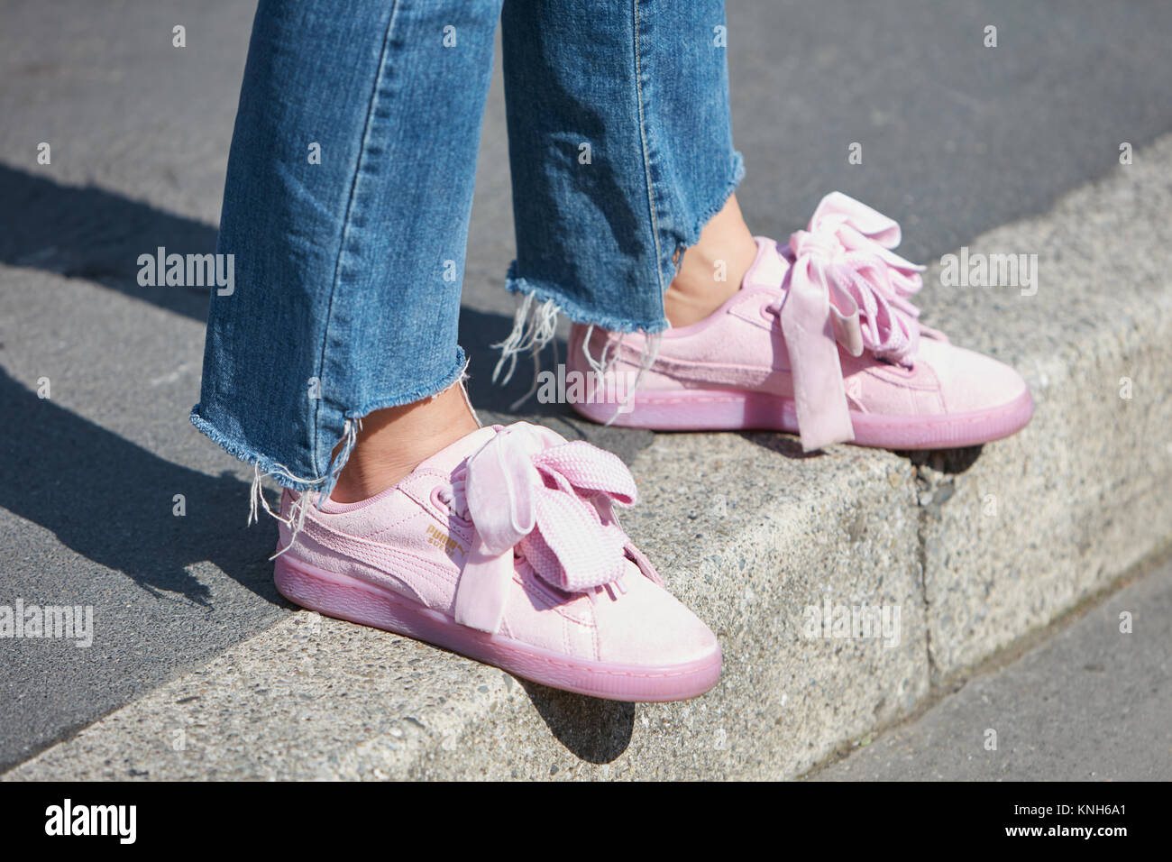 MILAN - SEPTEMBER 24: Woman with Puma suede pink shoes and torn blue jeans  trousers before Trussardi fashion show, Milan Fashion Week street style on  Stock Photo - Alamy