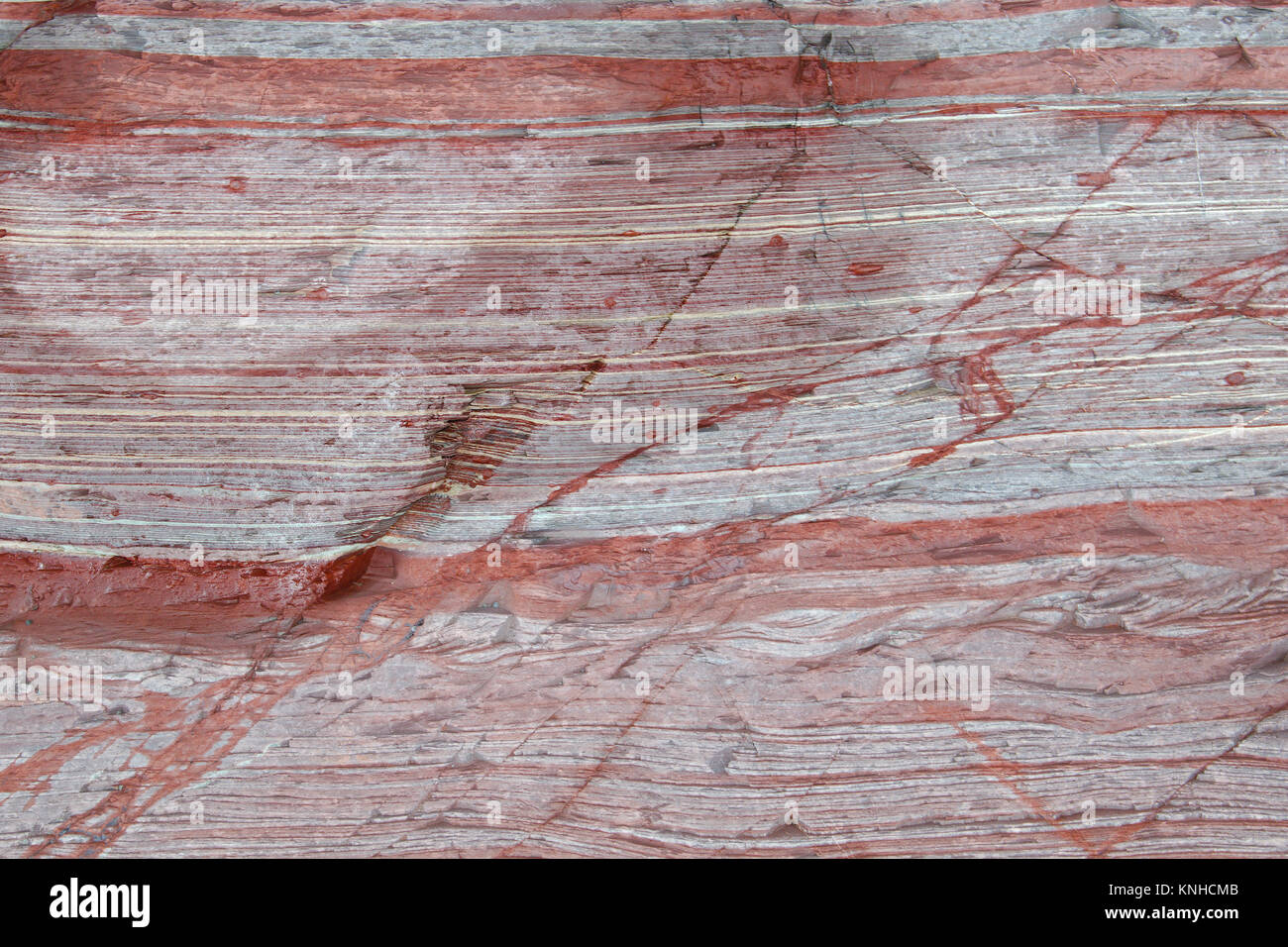 Close up of mostly red sediment layers in a rock formation. Stock Photo