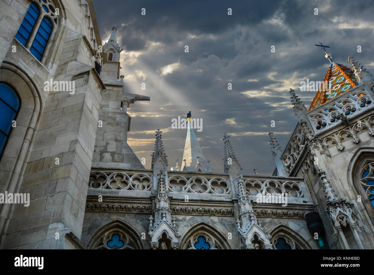 Matthias Church, a Roman Catholic church located in Budapest, Hungary in the Buda Castle District as a ray of sunlight through the clouds highlights. Stock Photo