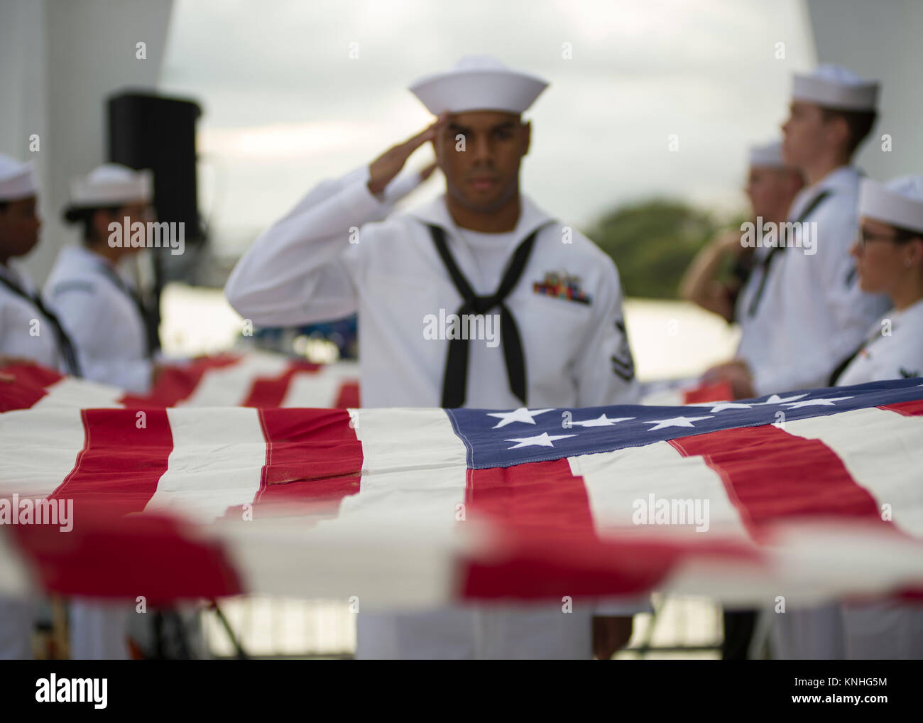 U.S. sailors prepare the American flag for presentation during the dual interment of two deceased World War II veterans from the ship USS Arizona during the 75th anniversary commemoration of the attacks on Pearl Harbor December 7, 2016 in Pearl Harbor, Hawaii. (photo by PO2 Somers Steelman via Planetpix) Stock Photo