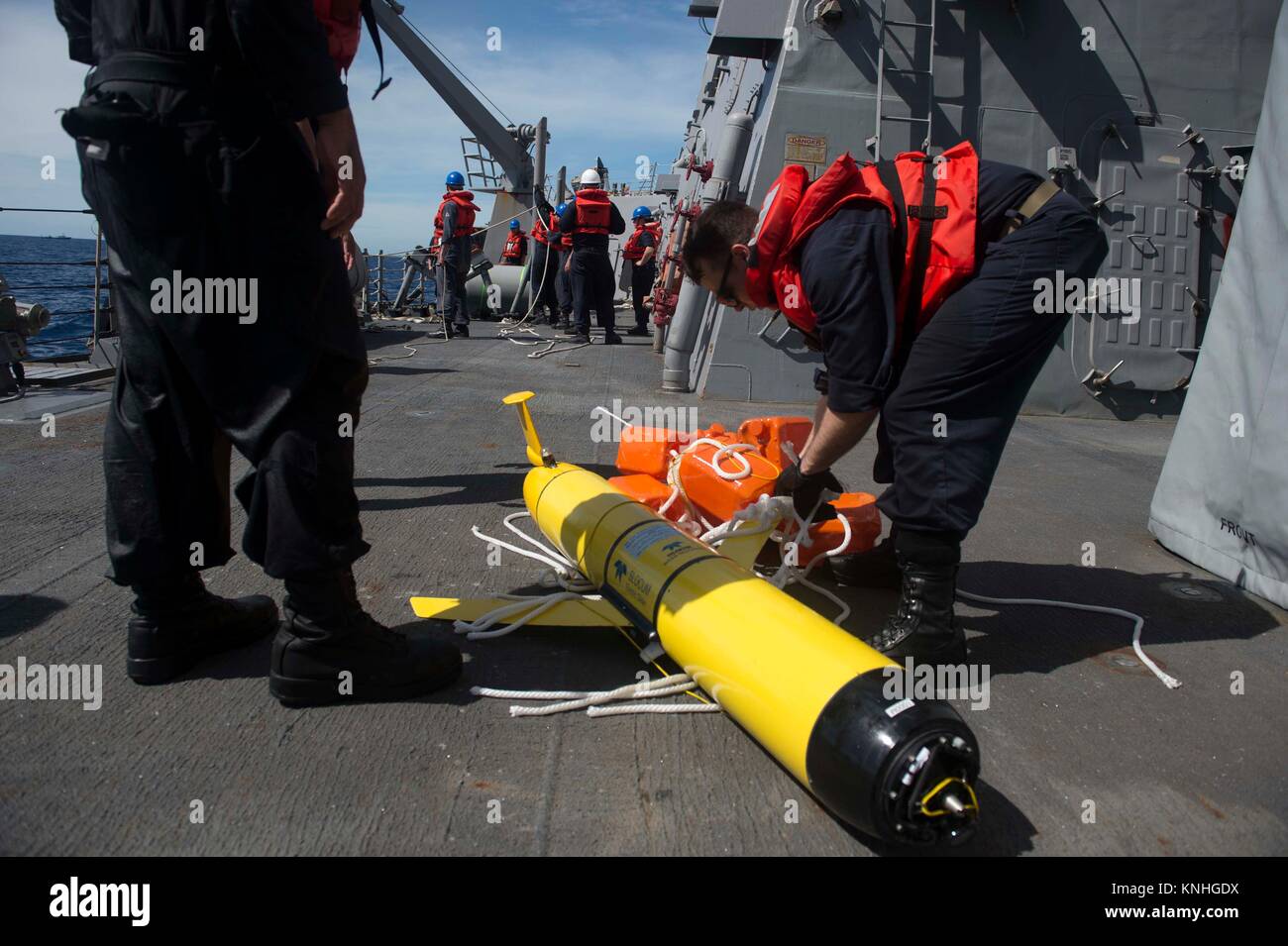 U.S. sailors aboard the USN Arleigh Burke-class guided-missile destroyer USS Mustin recover a U.S. Navy Ocean Glider Unmanned Underwater Vehicle December 20, 2016 in the South China Sea. (photo by Joshua Mortensen  via Planetpix) Stock Photo
