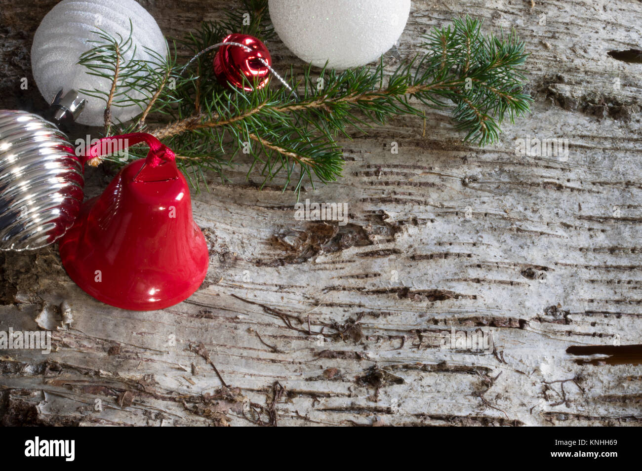 Wood bark background with christmas decoration, pine branch, balls and bells Stock Photo