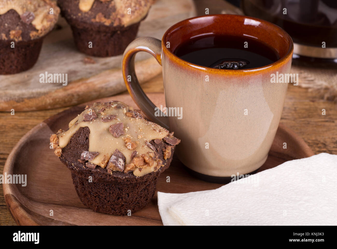 Chocolate cupcakes with peanut butter icing and chips and cup of coffee Stock Photo