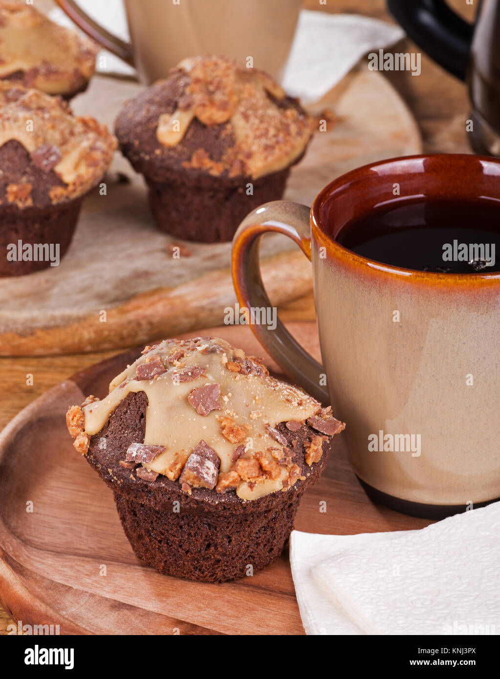 Chocolate cupcakes with peanut butter icing and chips and cup of coffee Stock Photo