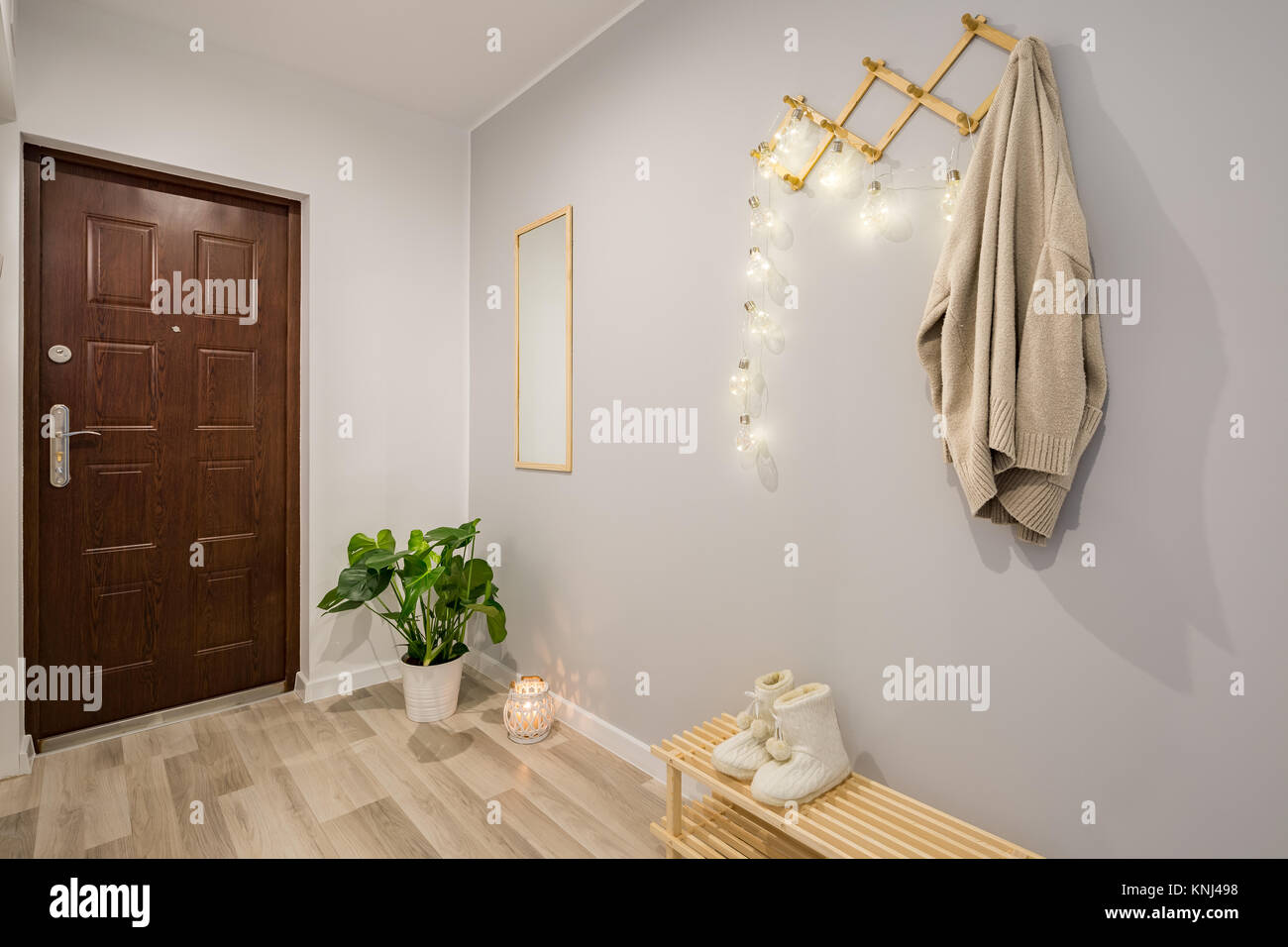 Simple entryway with gray walls, wooden door and decorations Stock