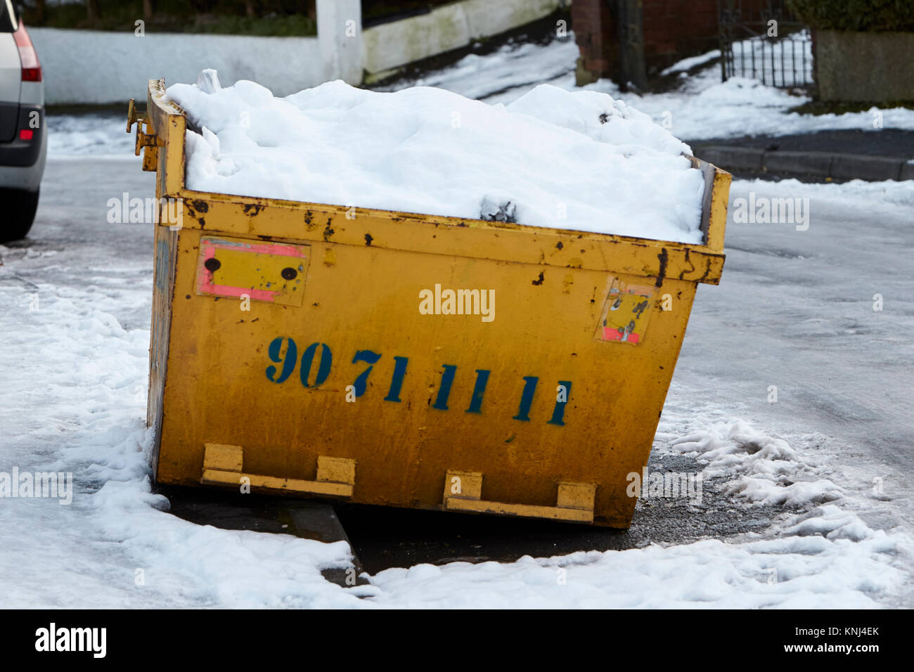 snow covered skip on an icy street with work stopped due to the bad weather newtownabbey northern ireland uk Stock Photo