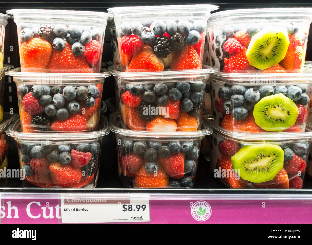 Mixed cut berries in plastic containers on a supermarket shelf in New York City Stock Photo