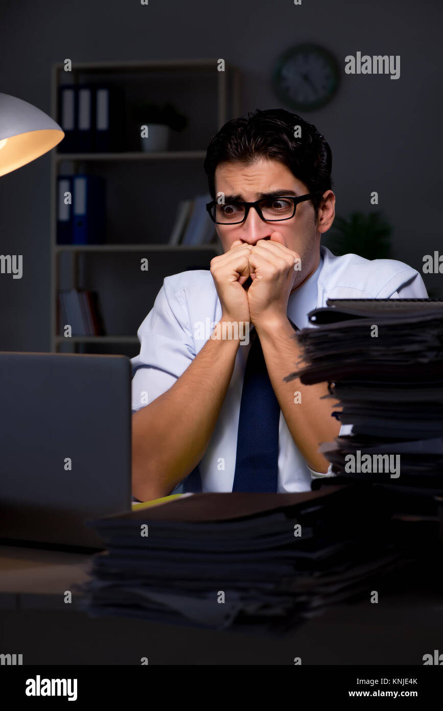Young businessman working overtime late in office Stock Photo - Alamy