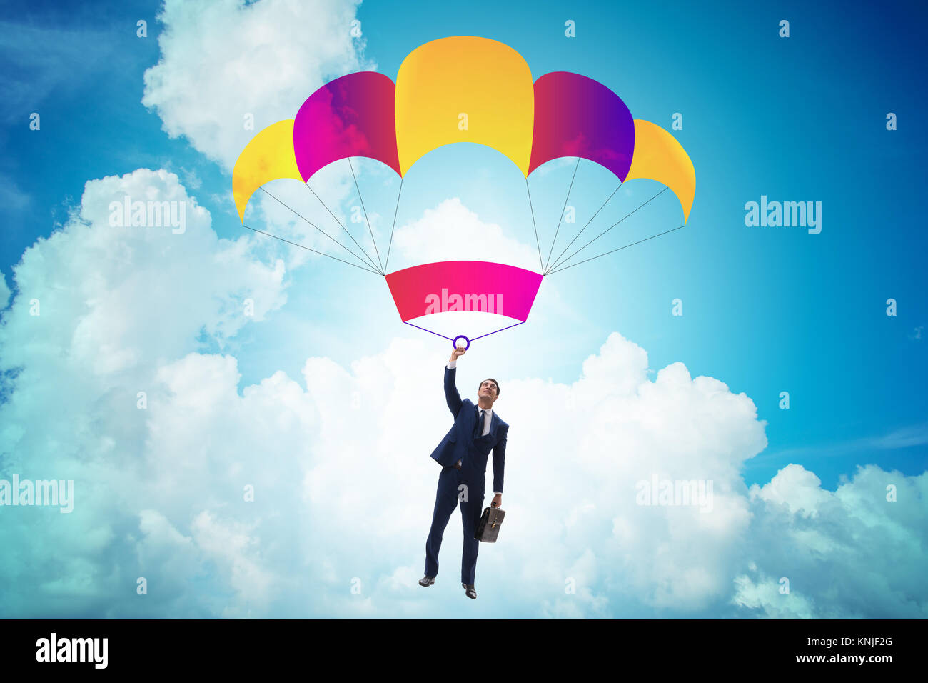 Young businessman falling on parachute in business concept Stock Photo