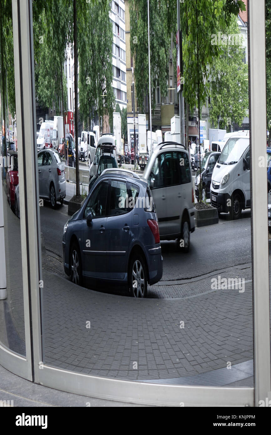 Brussels, Belgium. 24th June, 2017. Travelling and parked cars are reflected in a distorted way in the round glass pane of a building, in the Belgian capital Brussels, pictured on 24.06.2017. - NO WIRE SERVICE - Credit: Sascha Steinach/dpa-Zentralbild/dpa | usage worldwide/dpa/Alamy Live News Stock Photo