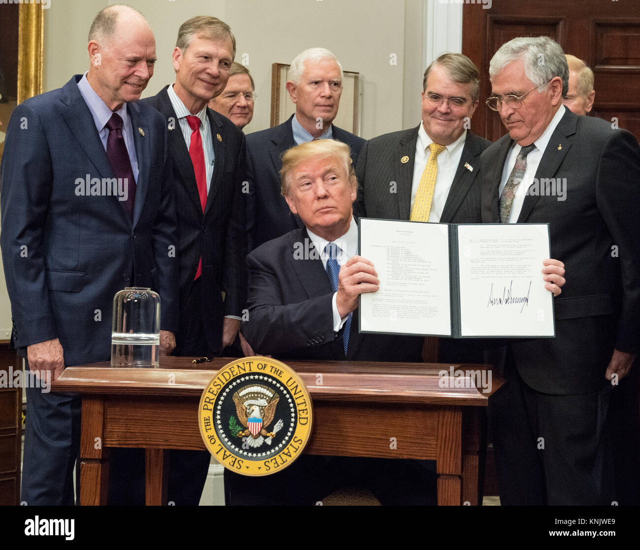 United States President Donald J. Trump signs the Presidential Space Directive - 1, directing NASA to return to the moon, alongside members of the Senate, Congress, NASA, and commercial space companies in the Roosevelt room of the White House in Washington, Monday, December 11, 2017. Credit: Aubrey Gemignani/NASA/CNP/AdMedia/Newscom/Alamy Live News Stock Photo