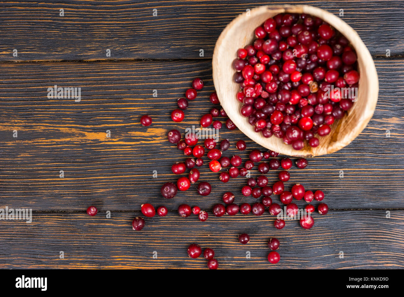 Top view of rowan berries in wooden plate on old wooden desk. Mockup for seasonal offers and holiday post card Stock Photo