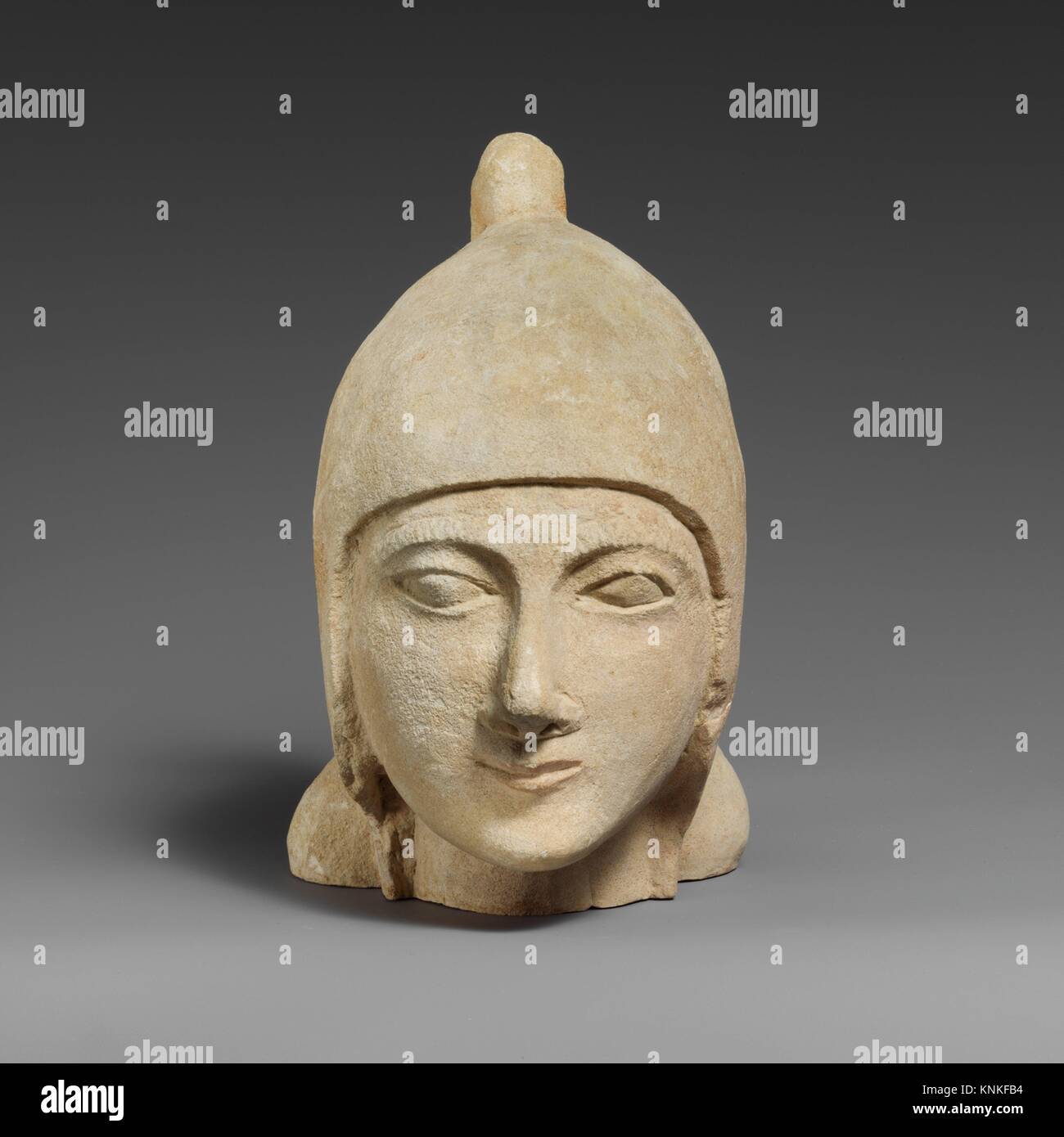 Limestone head of a beardless male wearing a conical helmet. Period Archaic; Date first half