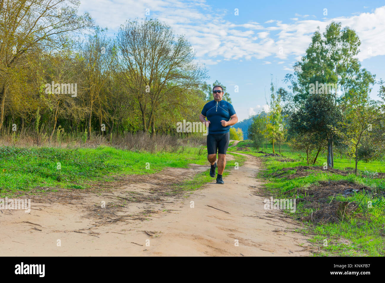 Big belly man jogging , exercising, doing cardio in the park , slightly