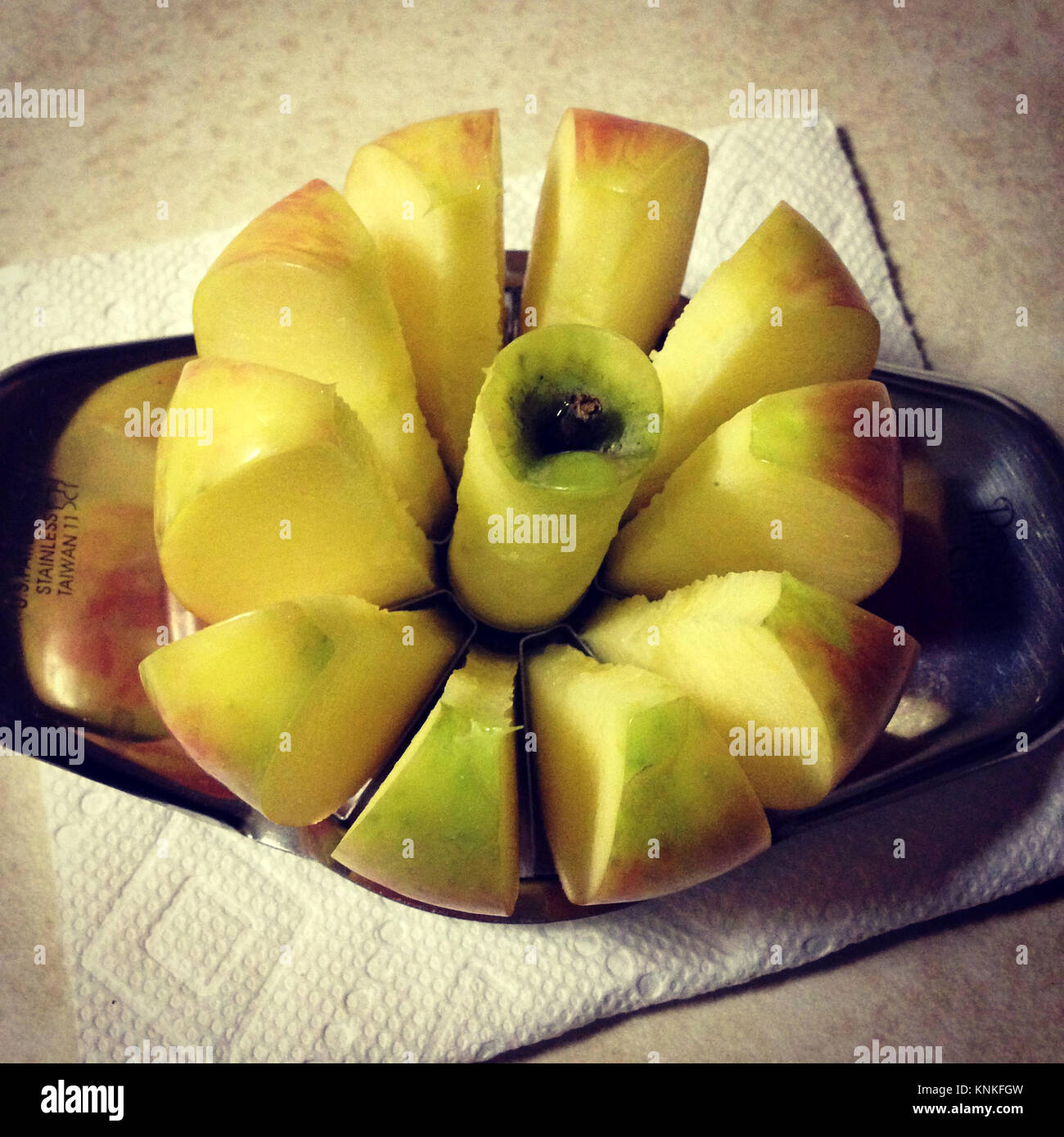 https://c8.alamy.com/comp/KNKFGW/apple-being-cut-with-an-apple-cutter-KNKFGW.jpg