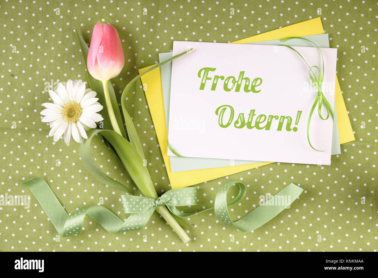 Greeting card with caption 'Frohe Ostern' ('Happy Easter' in  German) with flowers and ribbons Stock Photo