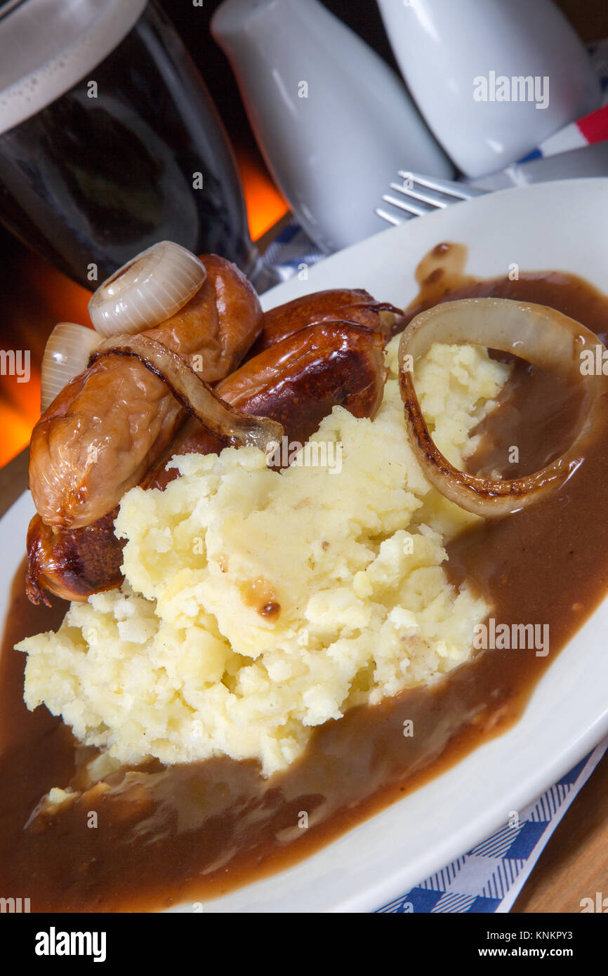 An English pub/restaurant dish of Sausage, Mashed potato and gravy topped with caramelized onion Stock Photo