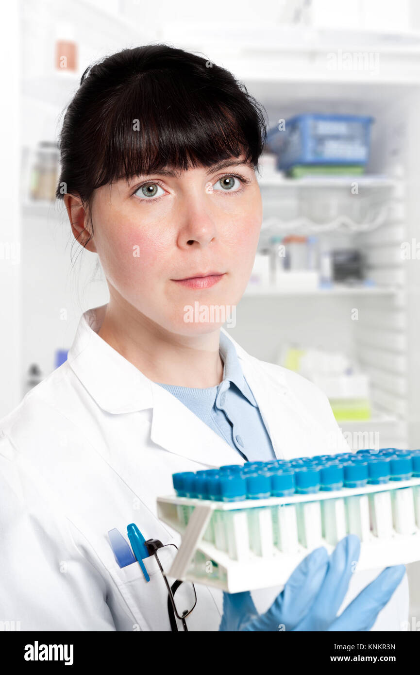 Serious clinitian, nurse or technical assistant takes samples out of the fridge Stock Photo