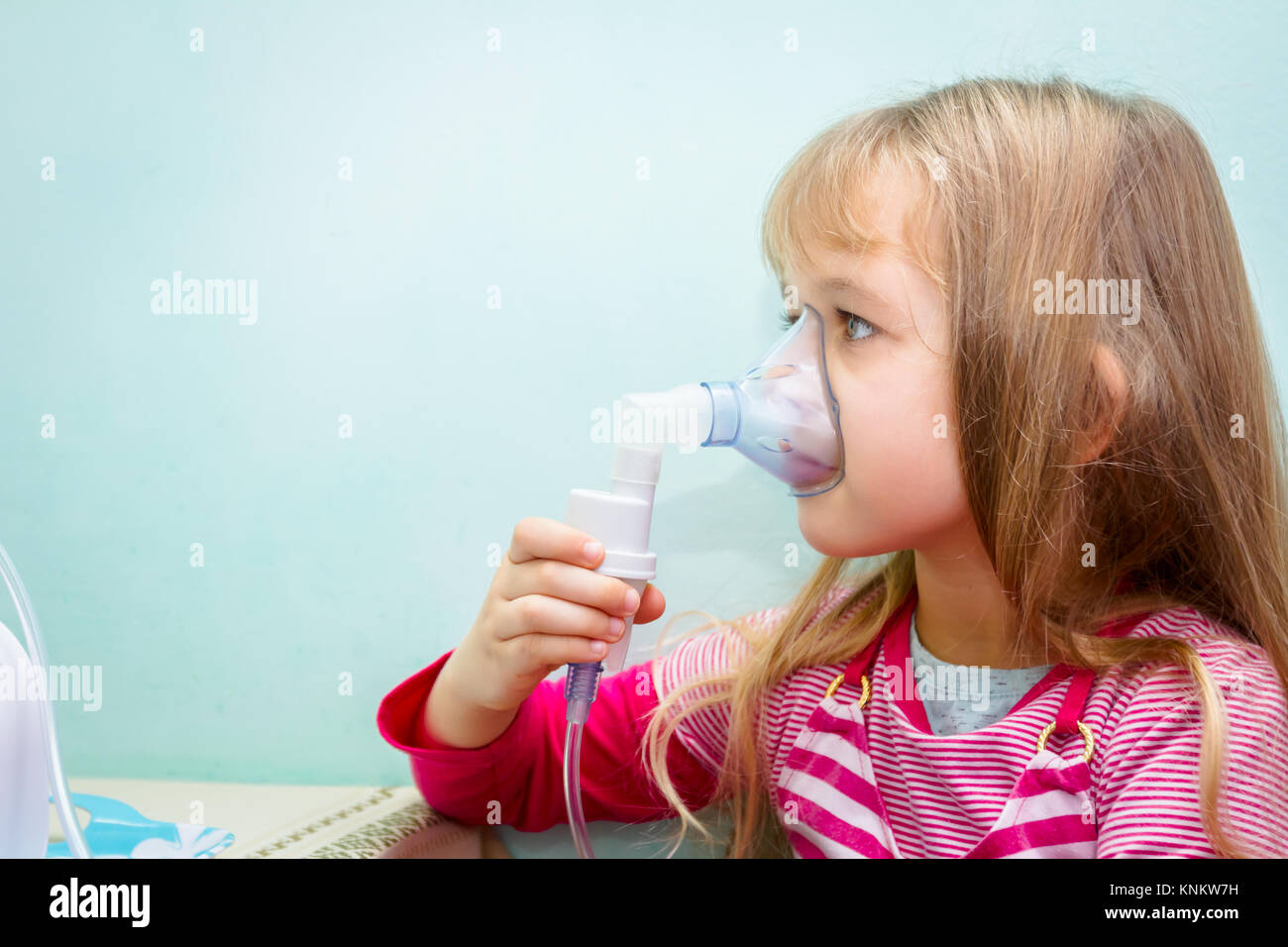 Child with asthmatic problems is take inhalation with mask on her face ...