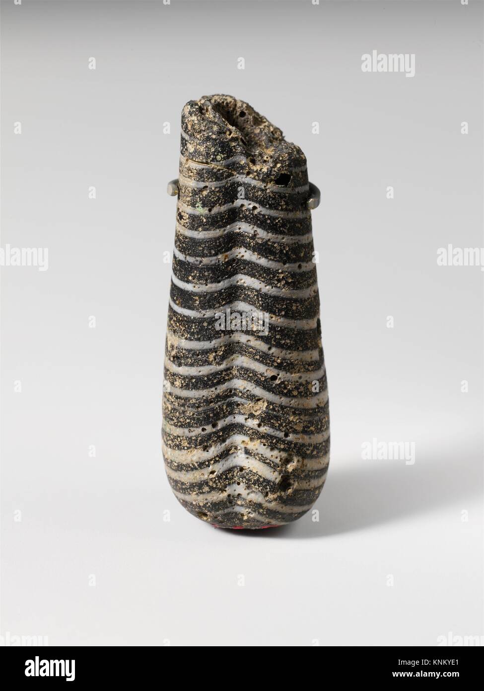 Glass pendant bead in the shape of a plumbline. Period Archaic or