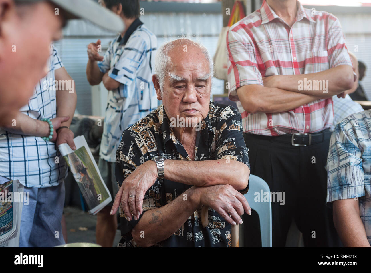 19.11.2017, Singapore, Republic of Singapore, Asia - Elderly men follow a game of Chinese Chess also known as Xiangqi at the Kreta Ayer Square. Stock Photo