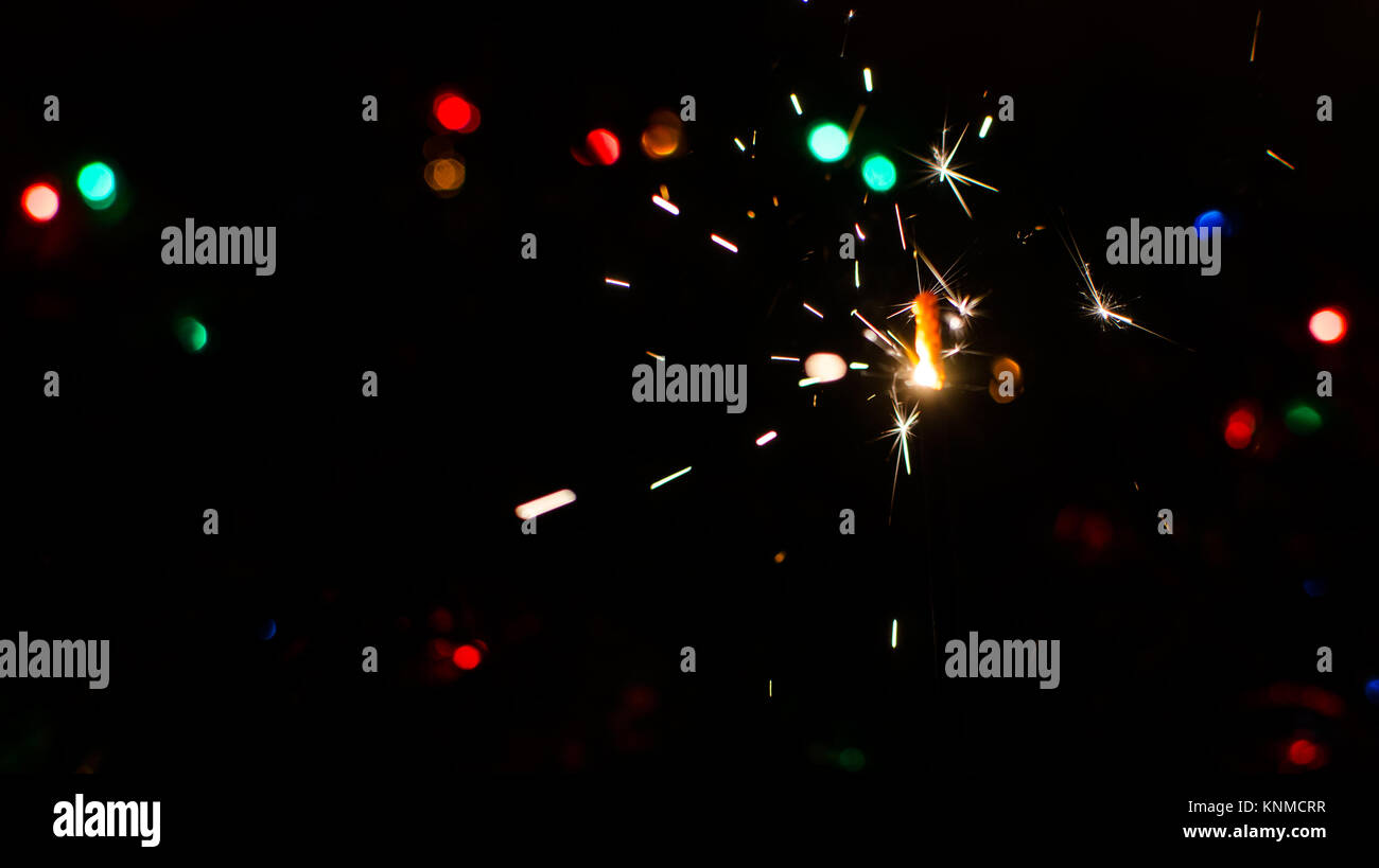 Sparkler and Christmas lights as an ideal background Stock Photo - Alamy