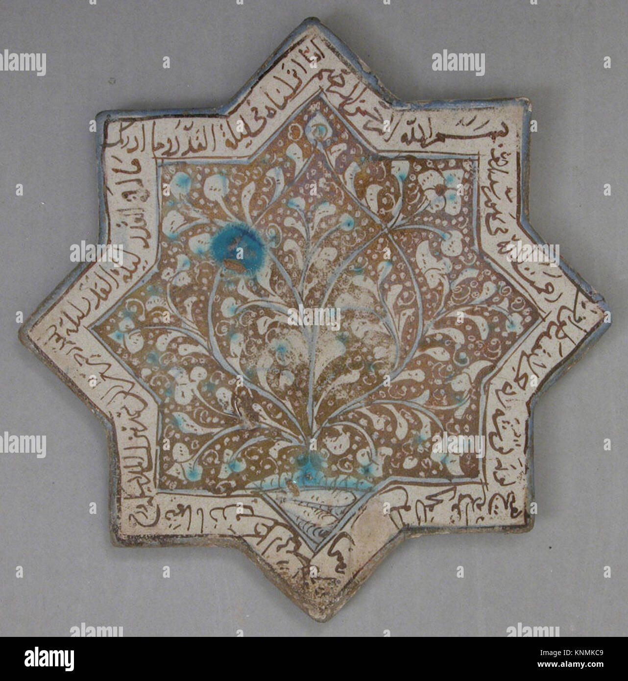 An eight-pointed star tile featuring foliage and an inscription ...