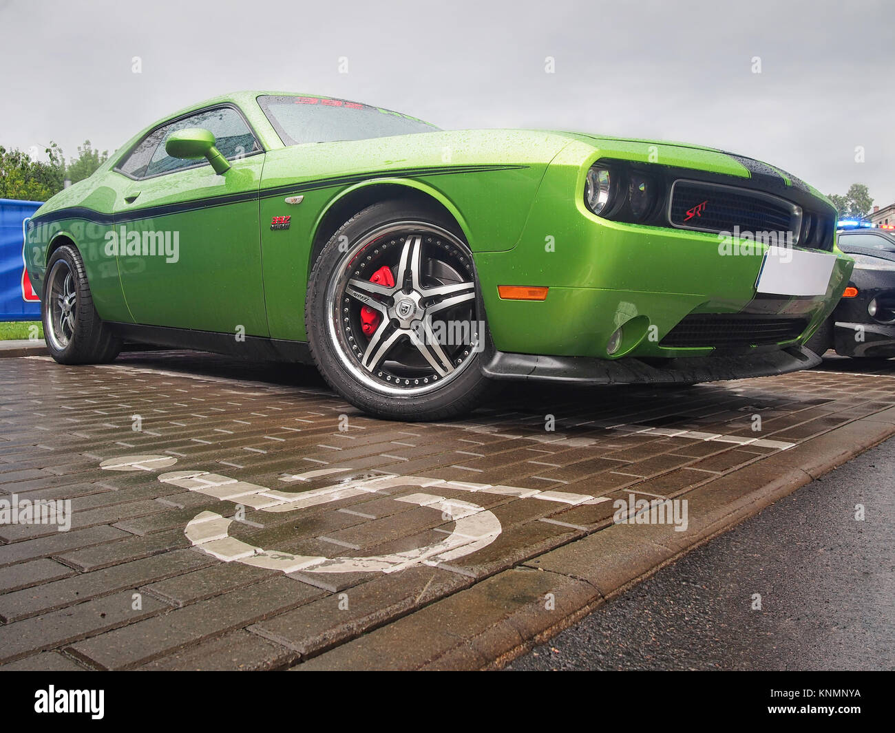 Green Dodge Challenger SRT HEMI 392 (third generation) in the rain. This model is one of the most popular cars for Stock Photo