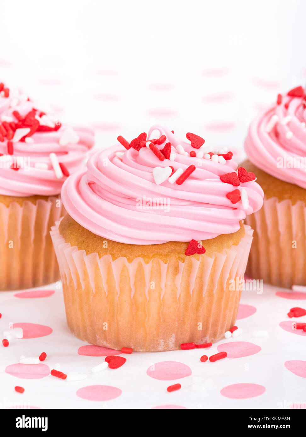 Pink Valentines Day cupcake with red and white heart shape sprinkles