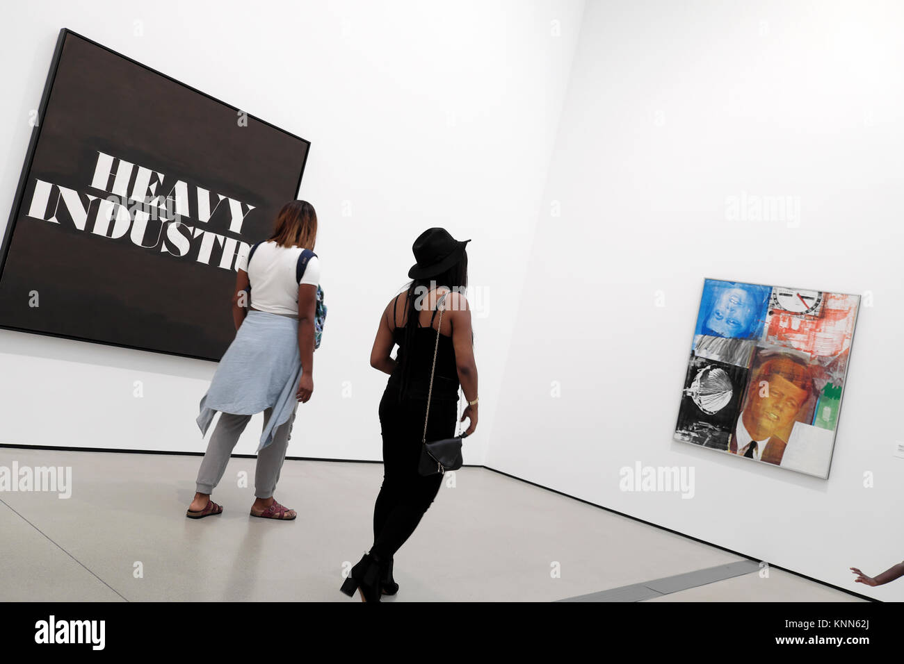Visitors looking at Ed Ruscha and Robert Rauschenberg paintings in a Broad Museum art gallery in downtown Los Angeles LA California USA  KATHY DEWITT Stock Photo