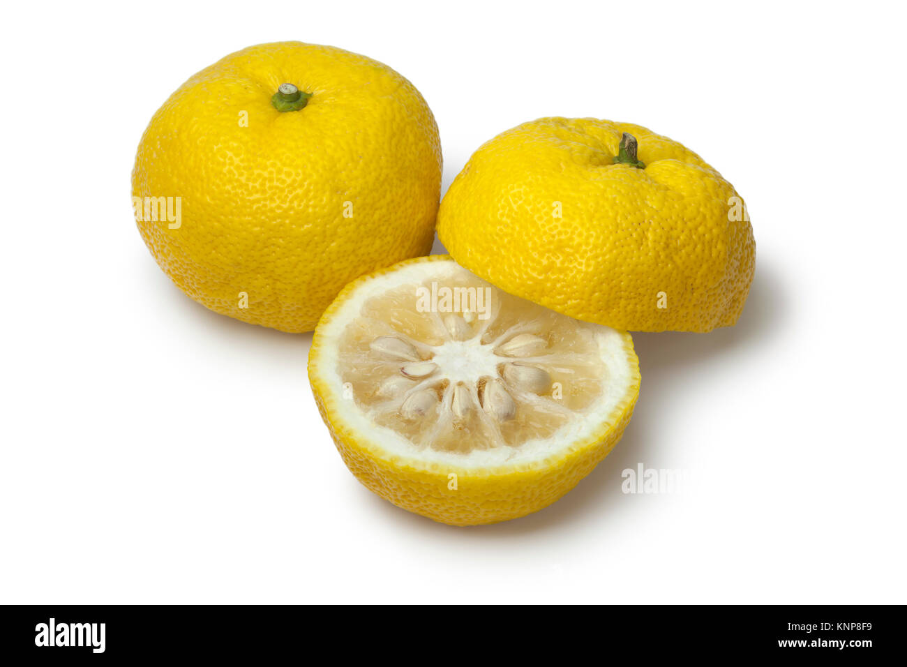 Pair of fresh yellow whole and half Japanese Yuzu on white background Stock Photo