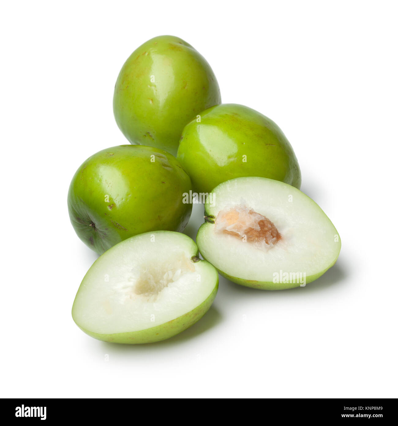 Fresh green whole and half Ambarella fruit with a fibrous pit on white background Stock Photo