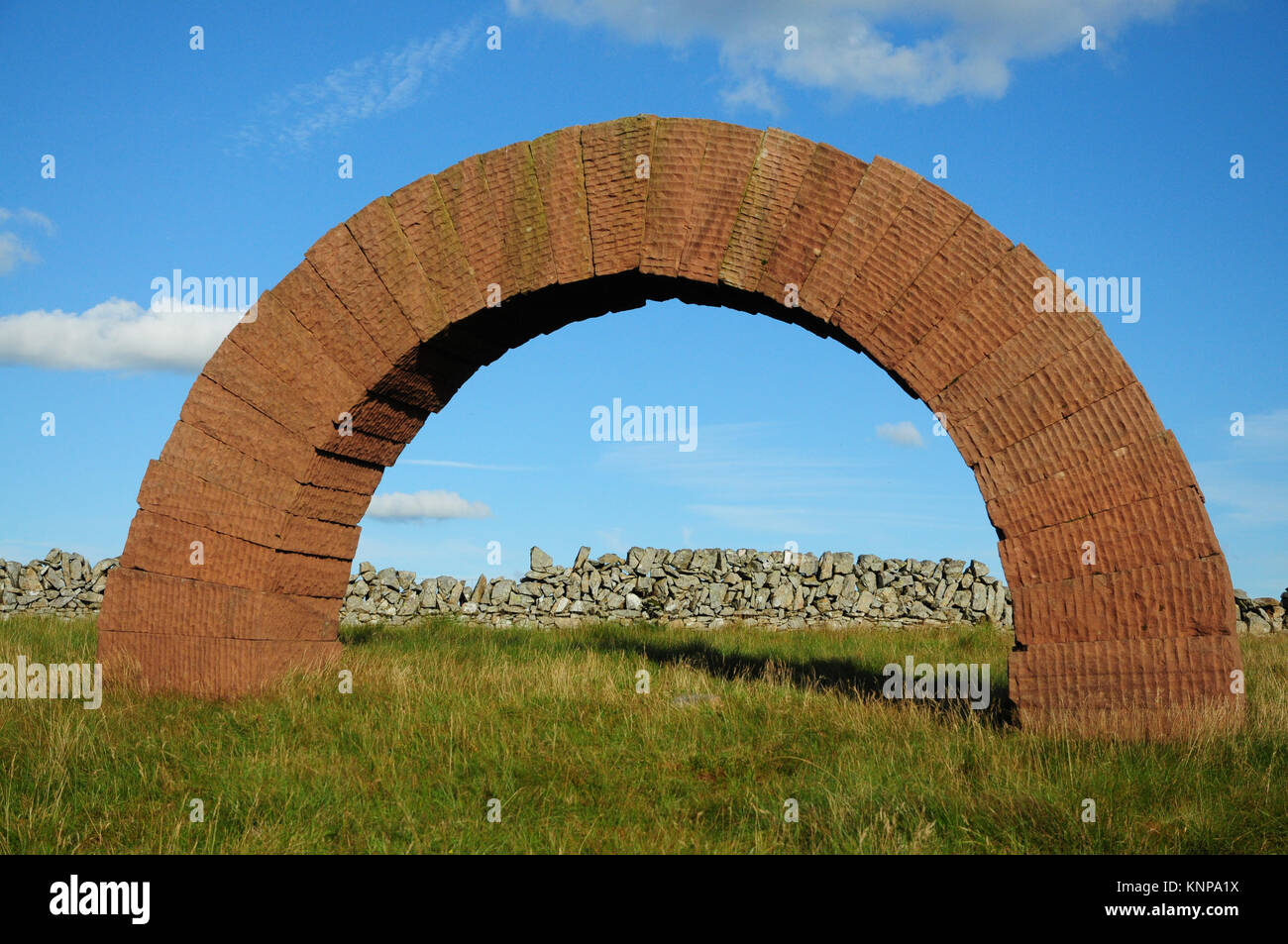 Free standing arch of red sandstone created by Andy Goldsworthy. One of a number on hill tops around Dumfries and Galloway Stock Photo