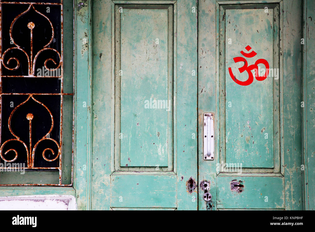 Om-sign on a green door Stock Photo