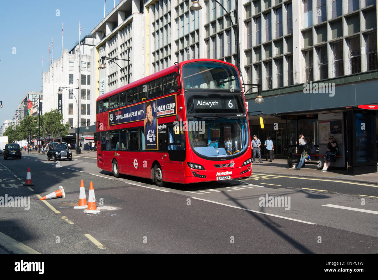 A Volvo B5LH hybrid bus with Wrightbus Gemini 3 bodywork. operated by  Metroline passes down Oxford Street. Cones mark a pot hole on the opposite lane Stock Photo