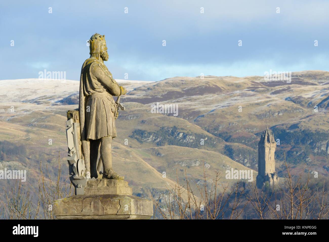 The King Robert Bruce statue looks out over Stirling, Scotland, UK, with the National Wallace Memorial monument in the background Stock Photo
