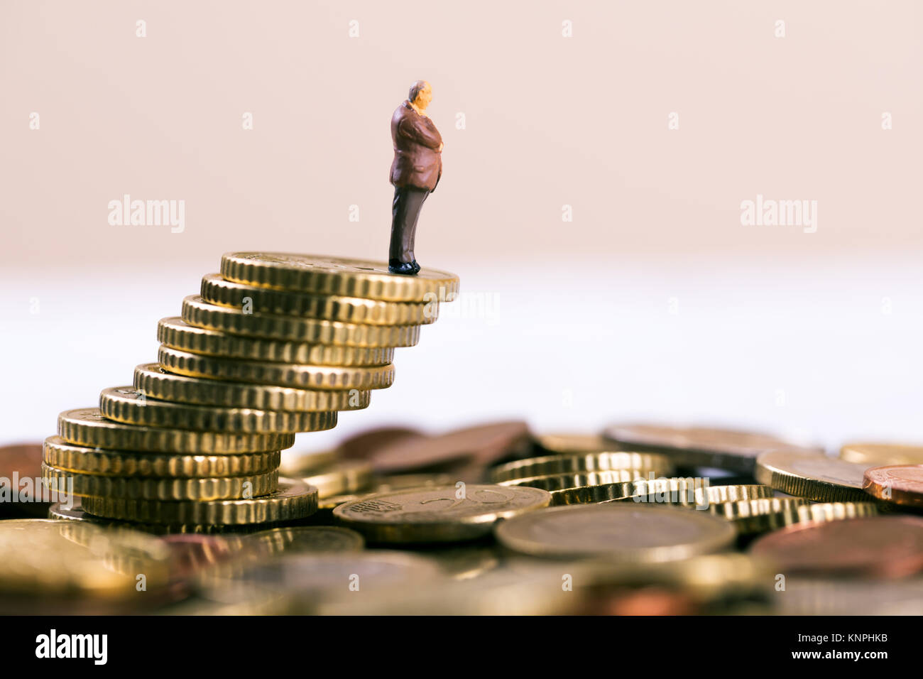 business bankruptcy and investment risk concept - businessman standing on falling stack of coins Stock Photo