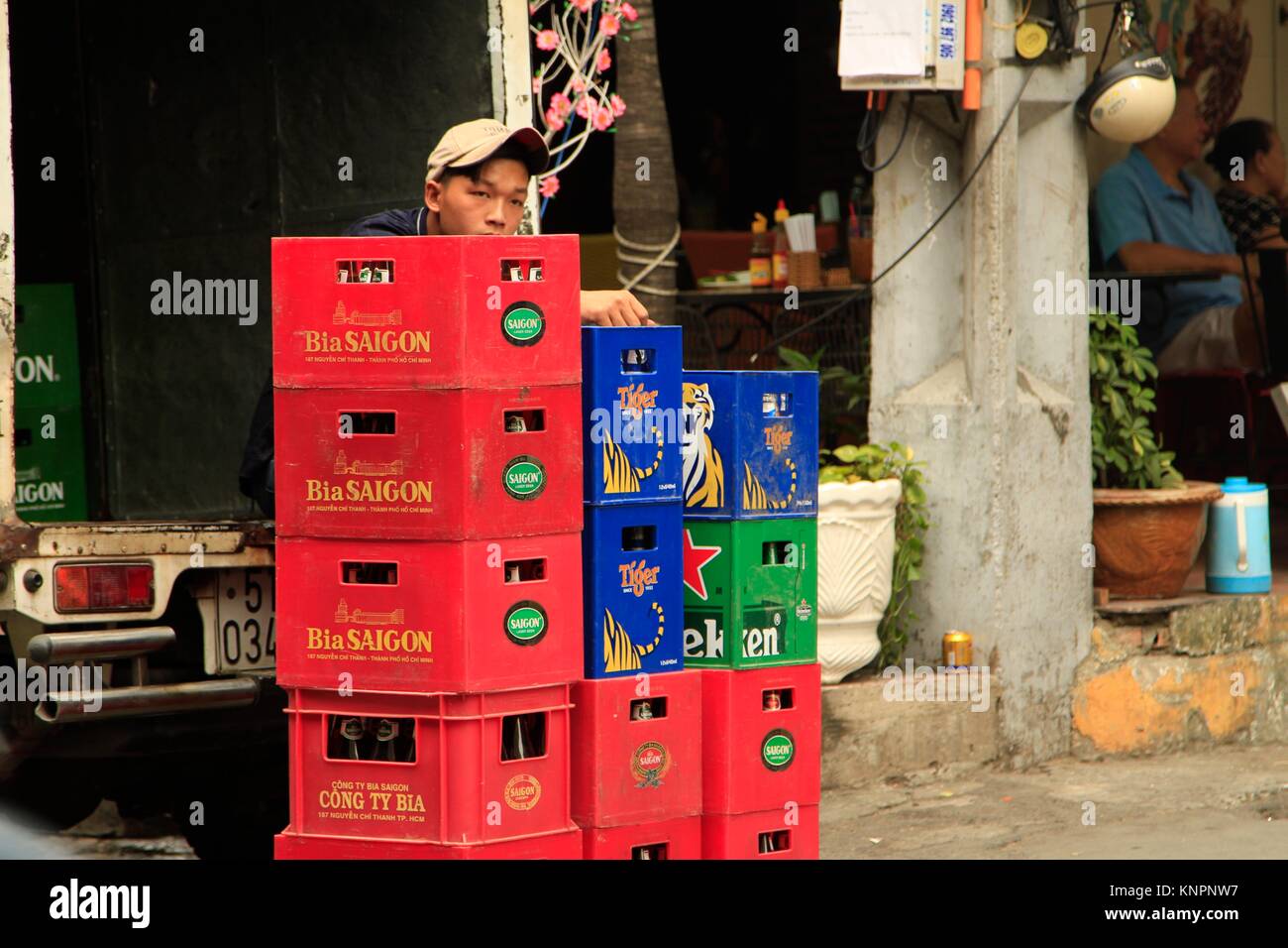 Man sitting on the back of a beer delivery truck in Ho Chi Minh City, Vietnam Stock Photo