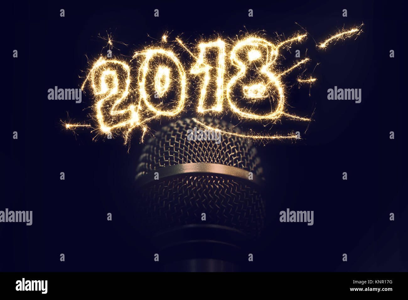 Singing on 2018 New Years Eve, karaoke audio microphone on dark background with sparkles Stock Photo